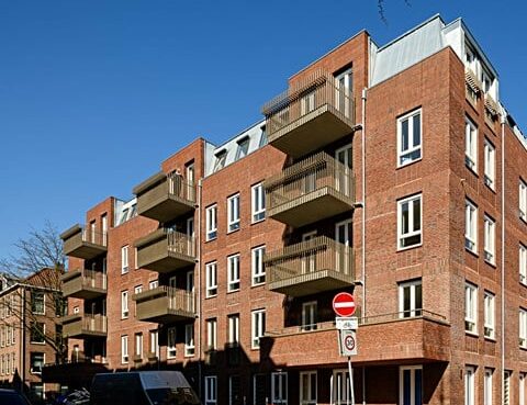 Modern appartementengebouw met balkons en blauwe lucht