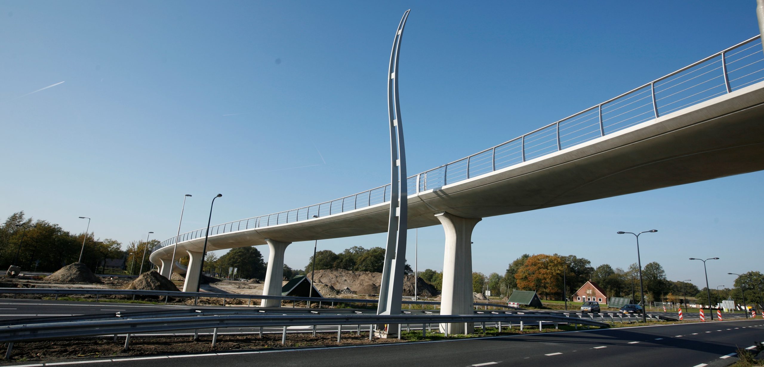 Futuristische voetgangersbrug over snelweg bij daglicht